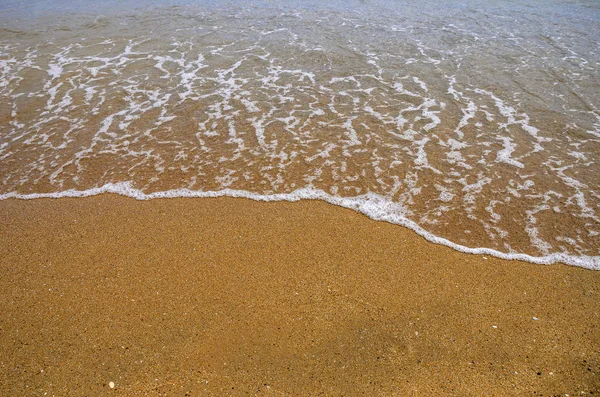 Arena húmeda en la playa. Una parte del mar es visible . — Foto de Stock