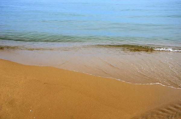 Υγρή άμμο στην παραλία. Ένα μέρος της θάλασσας είναι ορατό. — Φωτογραφία Αρχείου