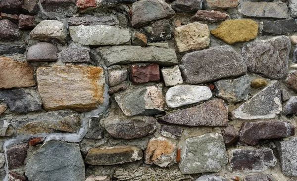 Textur der alten Steinmauer. Deutlich sichtbares Kopfsteinpflaster. — Stockfoto