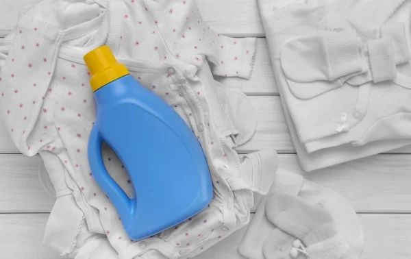 Dbać o ubrania dla dzieci. Łagodnym detergentem. Nacisk na butelce. — Zdjęcie stockowe