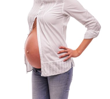 Beyaz bir gömlek ve beyaz bir arka plan üzerinde kot hamile kadın.
