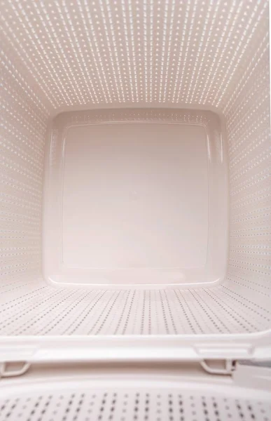 Empty plastic laundry basket with lid open.