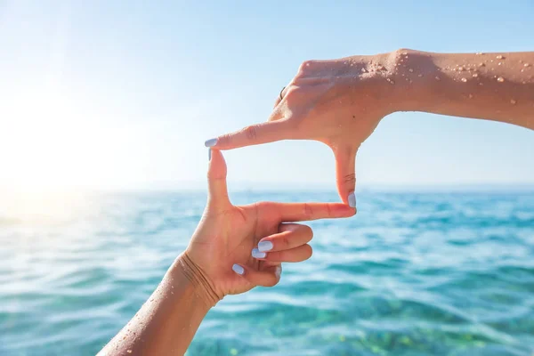 Human hands making frame against sea. — Stock Photo, Image