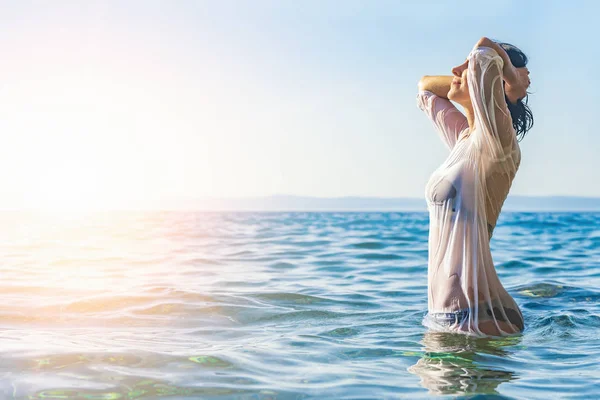 Happy woman enjoying beautiful sunset on the beach. — Stock Photo, Image