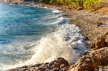 Kıyı taşlar üzerinde dalgalar beat.