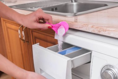 Bayan koyarak beyazlatıcı çamaşır makinesi eller içeri.