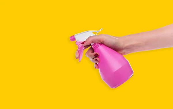 Spray palackot a női kéz a sárga háttér. — Stock Fotó