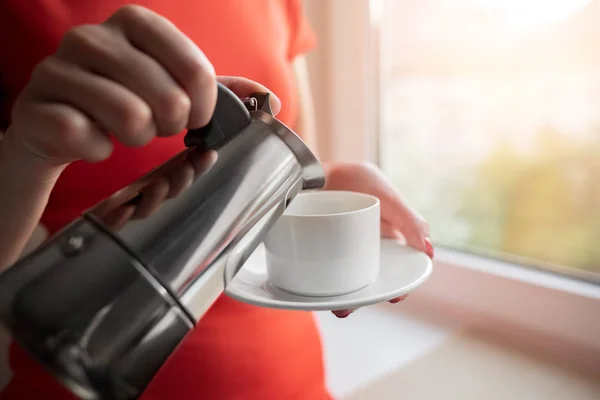 Une femme verse du café dans une tasse d'une cafetière . — Photo