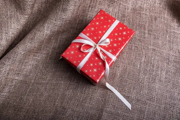 Christmas boxes with gifts on burlap background.