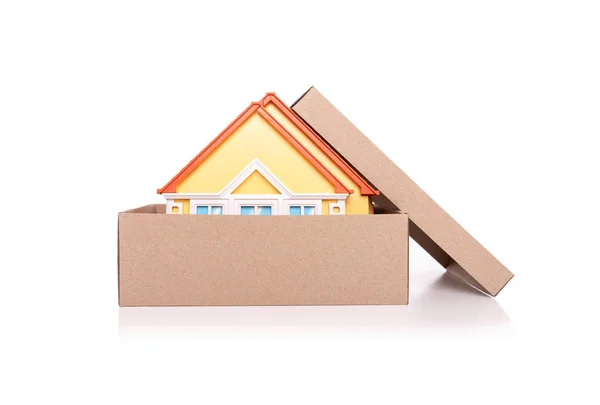 Μοντέλο παιχνιδιών ενός σπιτιού σε ένα χάρτινο κουτί σε λευκό φόντο. — Φωτογραφία Αρχείου