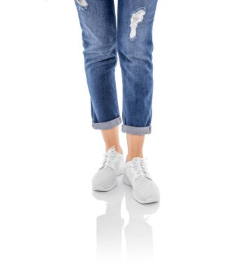 Beyaz arka planda izole kot pantolon ve beyaz spor ayakkabı bacaklar.
