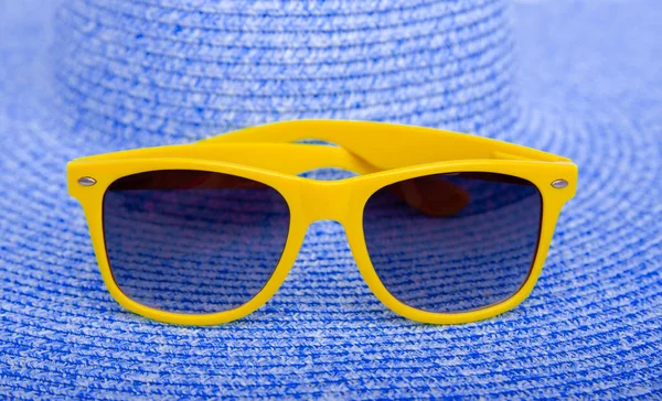 Gele zonnebrillen op een blauwe. — Stockfoto