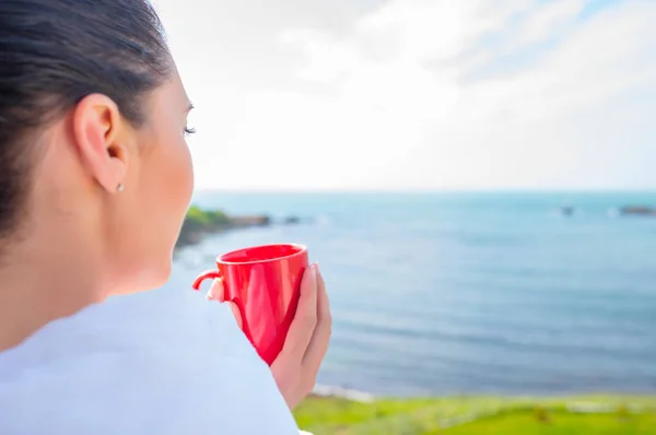 Girl wrapped in a blanket on the balcony in the morning drinks coffee or tea. — Stock Photo, Image