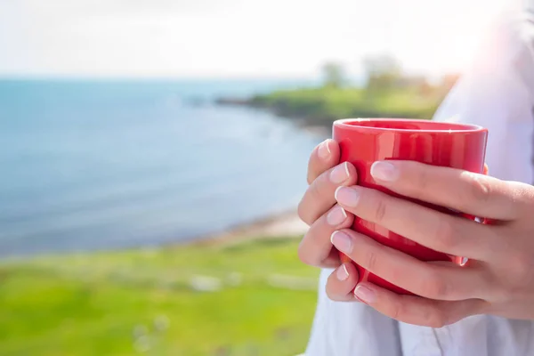 Fille enveloppée dans une couverture sur le balcon le matin boit du café ou du thé . — Photo