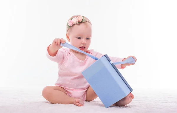 Little baby girl and a box with a gift on a white. — Stock Photo, Image