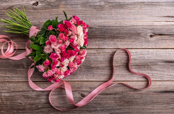 Ein Strauß Rosen auf einem hölzernen Hintergrund. — Stockfoto