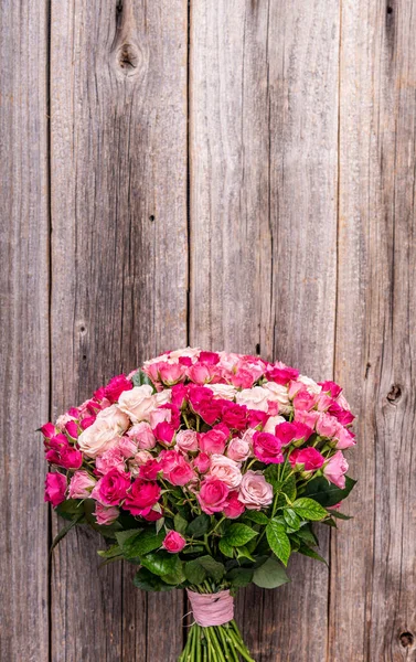 Un mazzo di rose su uno sfondo di legno . — Foto Stock