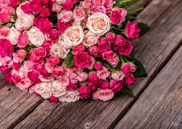 Un mazzo di rose su uno sfondo di legno . — Foto Stock