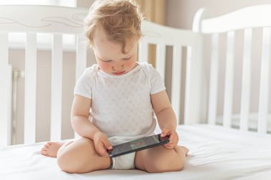 Küçük kız akıllı telefondan bir şey izliyor..