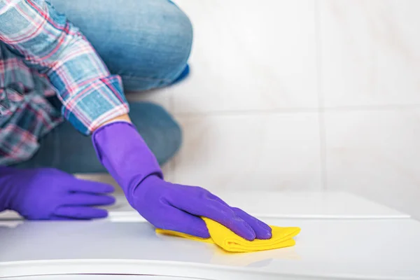 Pulizia in bagno. Una donna pulisce mobili in bagno . — Foto Stock