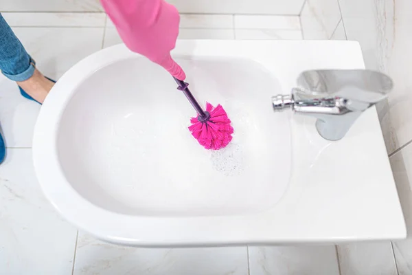 Una mujer limpia un inodoro . —  Fotos de Stock