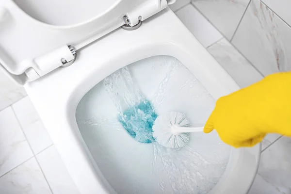 Uma mulher limpa um banheiro . — Fotografia de Stock