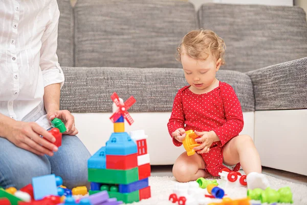 Annesiyle birlikte çok renkli oyuncak blokları ve küplerle oynayan bir çocuk.. — Stok fotoğraf