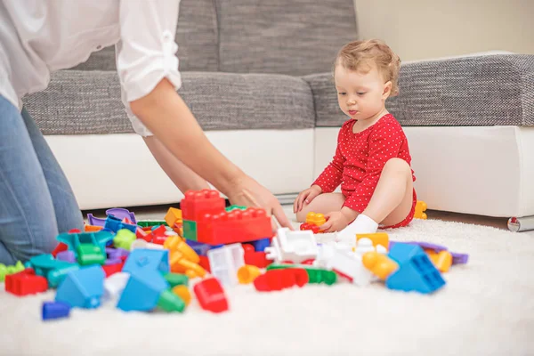Annesiyle birlikte çok renkli oyuncak blokları ve küplerle oynayan bir çocuk.. — Stok fotoğraf