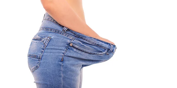 Fille mince en gros jeans sur un fond blanc. Perdre du poids . — Photo