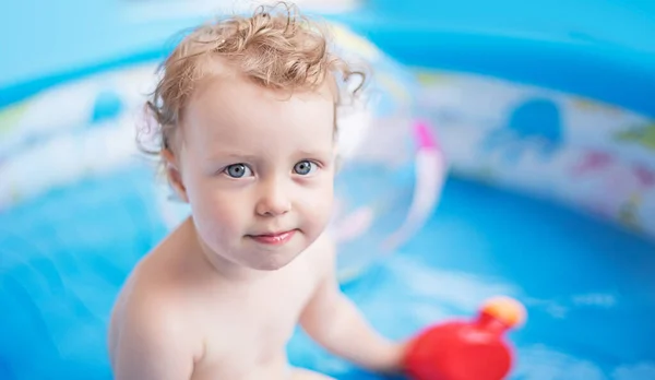 Child girl bathes in a bathtub or pool with toys. — Stock Photo, Image
