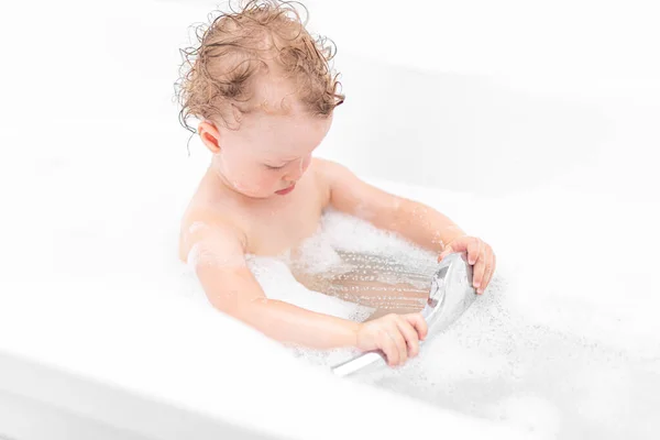 Une enfant fille se baigne dans un bain. — Photo