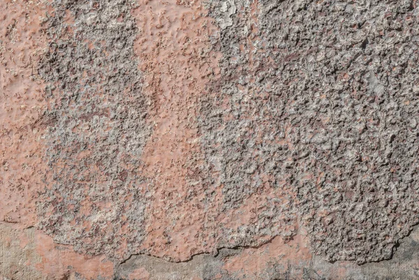 surface of the old wall with exfoliating and falling off paint as a background, abstract concrete, pink texture