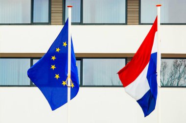 Avrupa Birliği ve windows ile beyaz bir duvar arka planı Hollanda bayrakları.