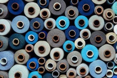 Farklı renklerde iplikler. Dikiş ve dikiş işleri için birçok iplik renk ve boyut olarak farklıdır. Tartışmaların rengarenk paleti.