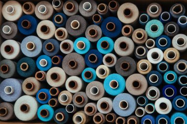 Farklı renklerde iplikler. Dikiş ve dikiş işleri için birçok iplik renk ve boyut olarak farklıdır. Tartışmaların rengarenk paleti.