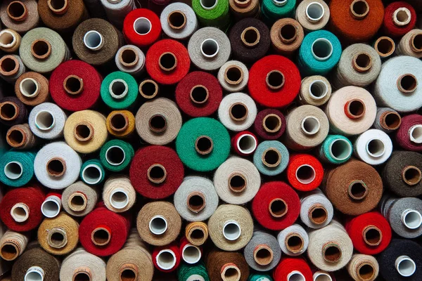 Farklı renklerde iplikler. Dikiş ve dikiş işleri için birçok iplik renk ve boyut olarak farklıdır. Tartışmaların rengarenk paleti.