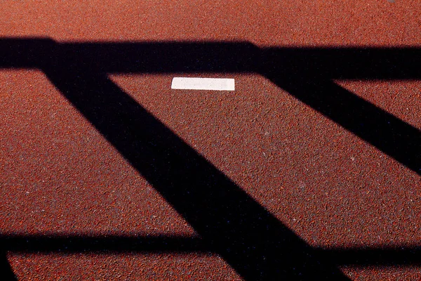 Dark shadows on a brown asphalt. Light and shadow, street, abstract concept.