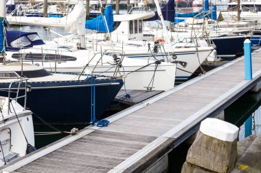 Birçok beyaz Yelkenli Scheveningen Lahey, Hollanda üzerinde limanda palamarla. Liman güzel açık gökyüzü ve deniz mavi arka plan ile teknede yerleştirme.