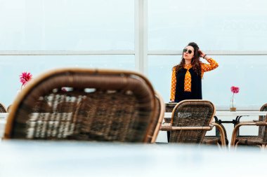 Bir kat kırmızı bir çiçek ile sahilde yalnız bir kız. Bir kadın denizde kafe, Rüzgar, yağmur.