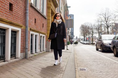 Ceket ve gözlük esmer bahar Avrupa kenti yürür. Sonbahar moda şık bir genç kadının portresi.