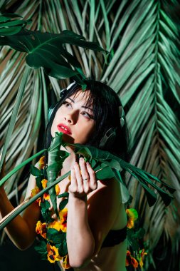 Esmer kız bikini tropikal yaprak zemin üzerine kulaklıklar müzik hoşlanır. Ekipman yaz Club müzik disko partisi DJ kadın çalış.