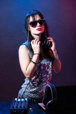 Kırmızı ve mavi zemin üzerine Dj genç kadın portresi. DJ kadın headphne ve siyah gözlük ile müzik disko çalıyor. Glamour parti yaz Club ekipman.