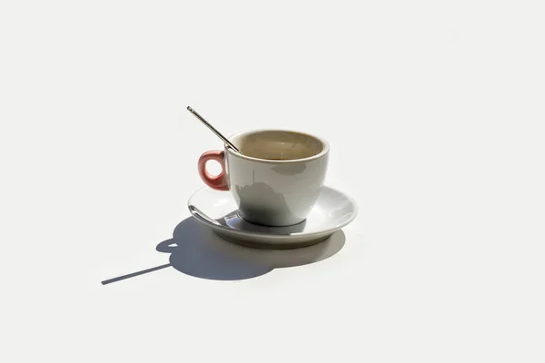 Filiżanka kawy białe tło tabeli cień kontrast zapomniane łyżka danie w lewo stracił izolowane światło słoneczne — Zdjęcie stockowe