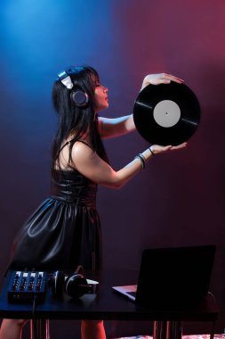 Kırmızı ve mavi zemin üzerine Dj genç kadın portresi. DJ ve kadın ile headphne vinyls müzik disko çalıyor. Glamour parti yaz Club ekipman.