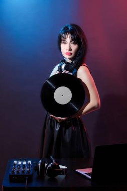 Kırmızı ve mavi zemin üzerine Dj genç kadın portresi. DJ ve kadın ile headphne vinyls müzik disko çalıyor. Glamour parti yaz Club ekipman.