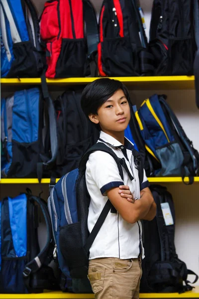 Азиатский Мальчик Выбирает Школьную Сумку Магазине Портрет Школьника Фоне Рюкзаков — стоковое фото