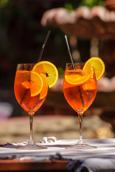 Aperol スプリッツ明るい日当たりの良いカフェに木製のテーブルの上のガラスのカクテル — ストック写真