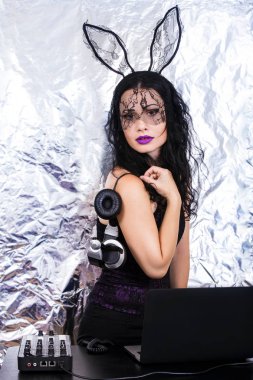 Esmer Dj dantel maskesi ve mor korse, Cadılar Bayramı kutluyor. Oyun ve müzik karıştırma kadın Dj. Cadılar Bayramı kavramı.