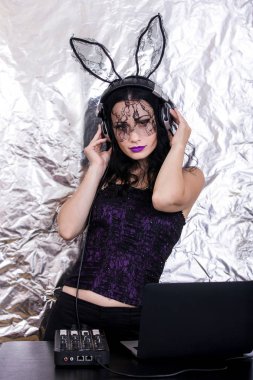 Esmer Dj dantel maskesi ve mor korse, Cadılar Bayramı kutluyor. Oyun ve müzik karıştırma kadın Dj. Cadılar Bayramı kavramı.