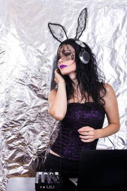 Esmer Dj dantel maskesi ve mor korse, Cadılar Bayramı kutluyor. Oyun ve müzik karıştırma kadın Dj. Cadılar Bayramı kavramı.